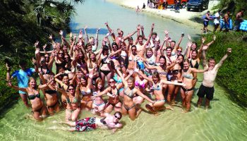 Large group of students in water at the beach